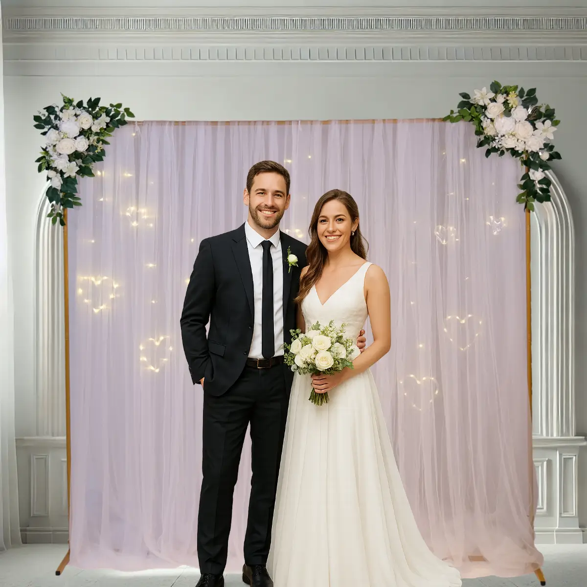 Kvadratisk guldfarvet bue med hvid chiffon, blomster og hjertelys