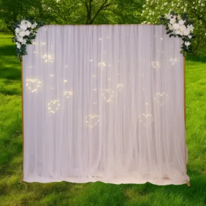 Kvadratisk guldfarvet bue med hvid chiffon, blomster og hjertelys